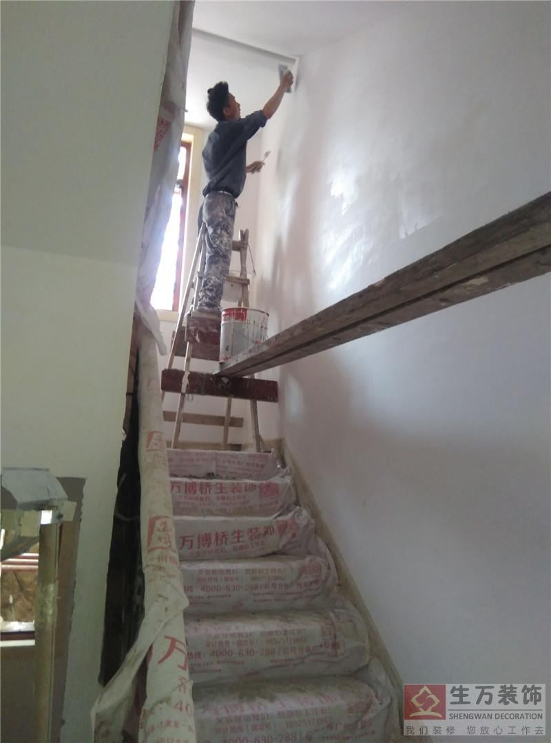 精装修扇油漆成师傅正在楼梯间扇第三篇灰。楼梯架空操作，采用120*80*6000MM加粗木枋做为板架，整个工程既将油漆中。